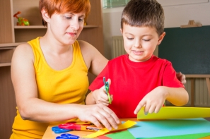 Mother cuts paper with his son