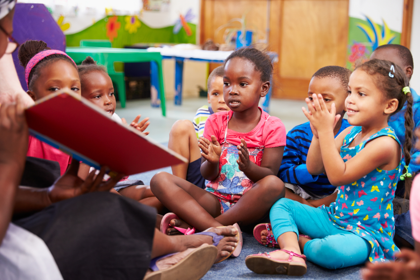 Teacher reading a book with a class of preschool children