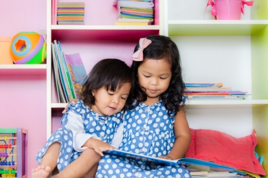 Child read, two cute little girls reading book together on books