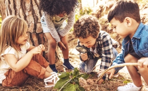 Kids in forest with a magnifying glass