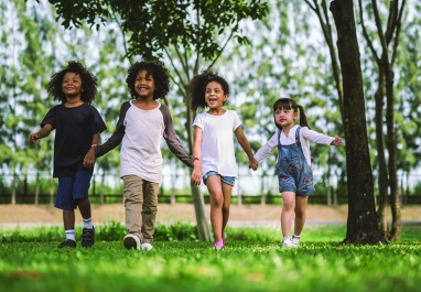 Cute diversity kids little boy and girl walking and hold hand in garden park