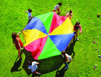 Kids going round in a circle with bright parachute