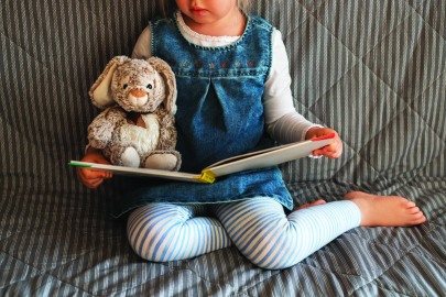 Little girl reading favorite book at home.