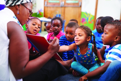 Teacher reading a book with a class of preschool children