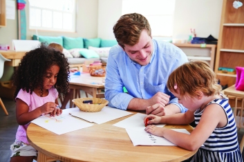 Teacher And Pupils Practicing Writing In Montessori School