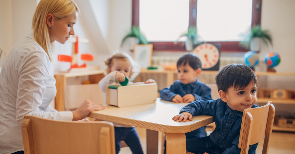 ECE overseeing group of toddlers engaging in a activity 